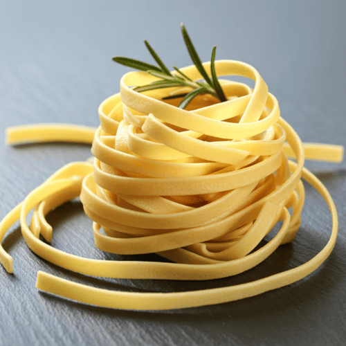 Fettuccine pasta with long, flat, medium-width ribbons.