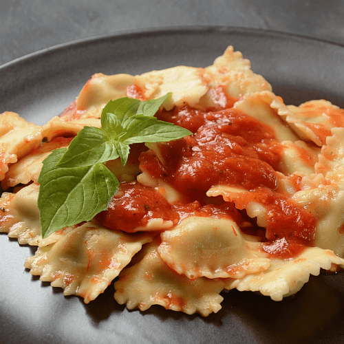 Ravioli pasta with filled square parcels and sealed edges.